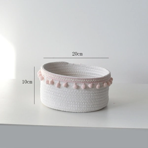 Detail showing 20cm diameter white woven cotton rope basket with pink pompom trim