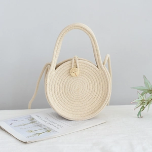 Détail du sac cabas rond tissé avec motif en spirale et bouton en bois gravé