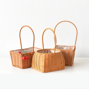 Set of three handmade woven flower baskets with plastic liners and tall curved handles