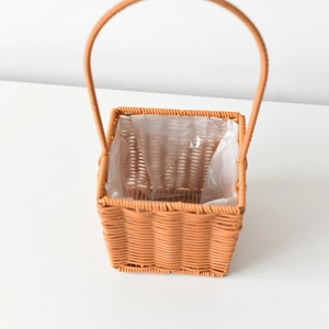 Detail of woven square flower basket with waterproof liner and tall handle