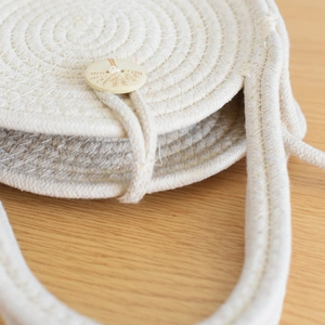 Détail du sac en coton tressé avec bouton en bois naturel et gravure de palmier élégante