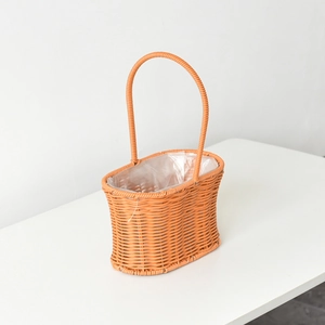 Close-up of handwoven orange plastic flower basket with waterproof lining and tall handle