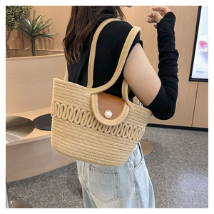 Detail of woven tote bag featuring a leather flap and large pearl decorative buckle
