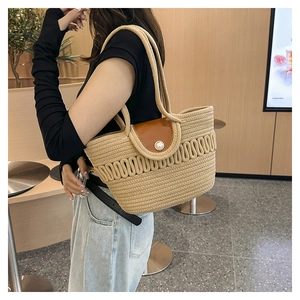 Detail of woven tote bag featuring a brown leather flap and a large pearl fastener