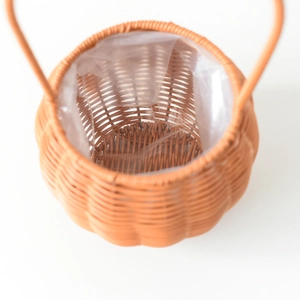 Detail of hand-woven pumpkin shaped flower basket with durable plastic liner and handle