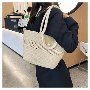 Detail of hand-woven cream tote bag featuring a leather flap and large pearl buckle closure