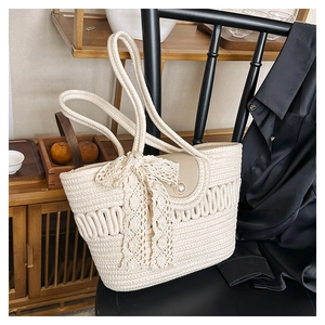 Detailed close-up of woven tote bag with elegant lace bow and decorative pearl buckle
