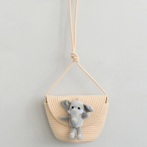Detail of creative elephant plush decor on beige woven cotton rope crossbody bucket bag