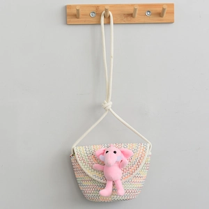 Detail of a kids straw crossbody bag with pink elephant plush toy and wavy colorful stitching