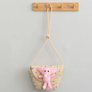 Detailed view of beige cotton woven kids crossbody bag with a cute pink plush elephant