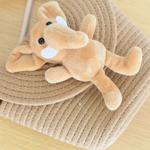 Detailed view of handmade woven straw bag featuring a cute plush elephant doll ornament