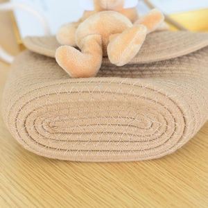 Macro view of woven spiral bottom texture and reinforced stitching on straw bucket bag