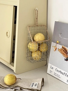 Detail of silver wire wall basket with beige fiber rope edging and metal grid design