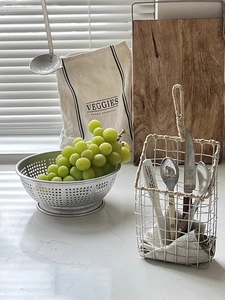 Macro shot of stainless steel wire storage basket with woven handles for kitchen cutlery