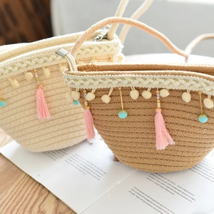 Handmade woven mini straw bag with pom-poms and tassels for children beach fashion