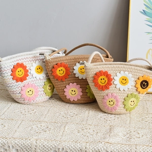 Détail de sacs en paille avec fleurs au crochet colorées et motifs de smileys