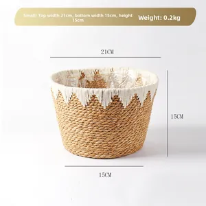 Detail of woven straw flower basket with white cotton tassels and plastic lining