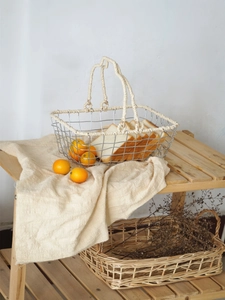 Detail of Nordic iron storage basket with woven cotton handles and silver wire mesh