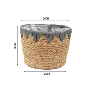 Detail of hand-woven straw basket with grey tassels and waterproof plastic lining