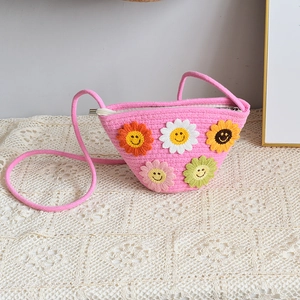 Détail d'un sac bandoulière rose tissé à la main avec des fleurs de soleil au crochet