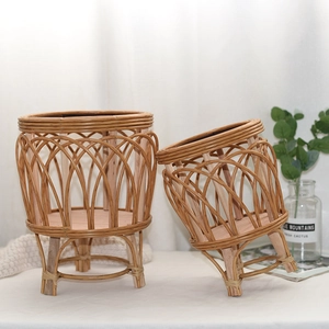 Detail of handwoven rattan planters with natural wood grain and three-legged wood stand