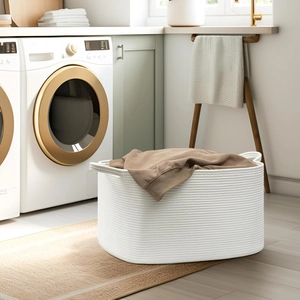 Close-up of woven cotton rope laundry basket with hidden handles and a soft brown sweater