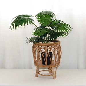 Detail view of woven rattan plant stand with solid wood legs and hand-crafted texture