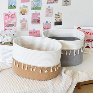 Close-up of woven cotton rope baskets with tassels in a cozy minimalist home setting