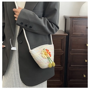 Détail d'un mini sac tissé main à rayures colorées avec des accents floraux en 3D