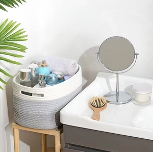 Handwoven grey and white cotton rope storage basket with handles for bathroom organization