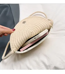 Detail view of woven crossbody bag interior showing space for phone and notebook