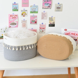 Detail of woven cotton rope baskets with fringe and plush liner in a cozy setting