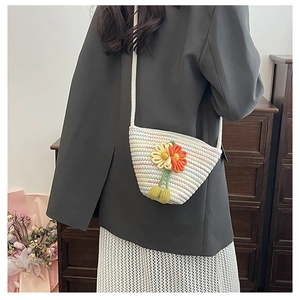 Detail of hand-woven crossbody bag with 3D crochet flowers and thin shoulder strap