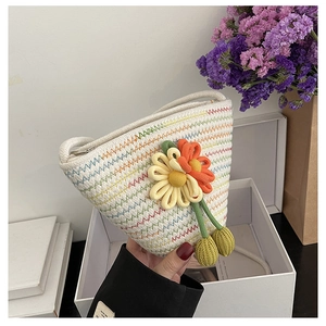 Détail d'un sac seau tissé à la main avec fleurs au crochet 3D et motifs ondulés
