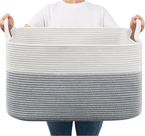Large rectangular cotton rope storage basket with grey gradient held by hand for size
