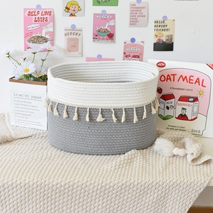 Detailed macro view of woven cotton rope basket texture with white tassels and grey finish