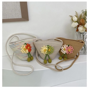 Detailed close-up of woven cotton bucket bags with 3D floral accents and shoulder straps