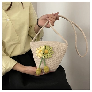 Detail of hand-woven cream bag featuring 3D sunflower elements and knit drawstring handle