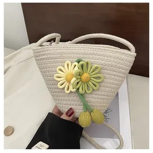Detail of hand-woven cream crossbody bag featuring yellow sunflower charms and zipper