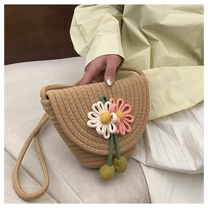Close-up of woven flower crossbody bag with handmade floral details and straw strap