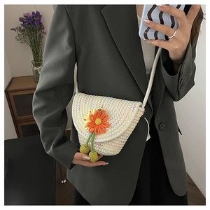Close-up of woven floral bag with orange flower detail and white braided texture