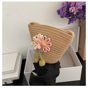 Detail of hand-woven straw crossbody bag featuring 3D floral accents and textures
