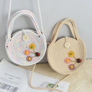 Detail of round cotton rope woven bags with 3D floral accents and wooden button