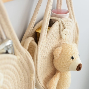 Detail of round straw bag with bear charm and engraved button on woven fabric