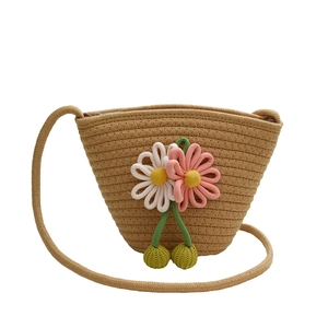 Close-up of handmade straw woven bag with colorful crochet flower and green tassel