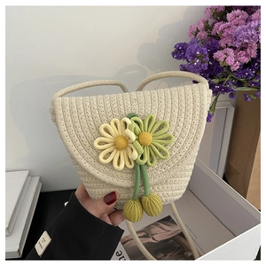 Detail of cream woven crossbody bag featuring handcrafted yellow sunflower accents