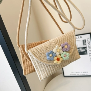 Detail view of hand-woven crossbody phone bags with colorful crochet flower decorations