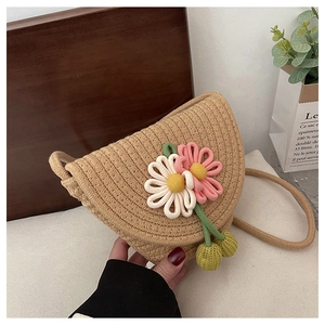 Detail of hand-woven straw crossbody bag with 3D floral accents and braided rope strap