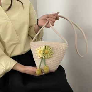 Elegant beige woven crossbody bag with daisy flower accents for a trendy summer look
