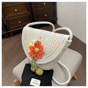 Detail of the handmade woven texture and large orange crochet flower on the bag